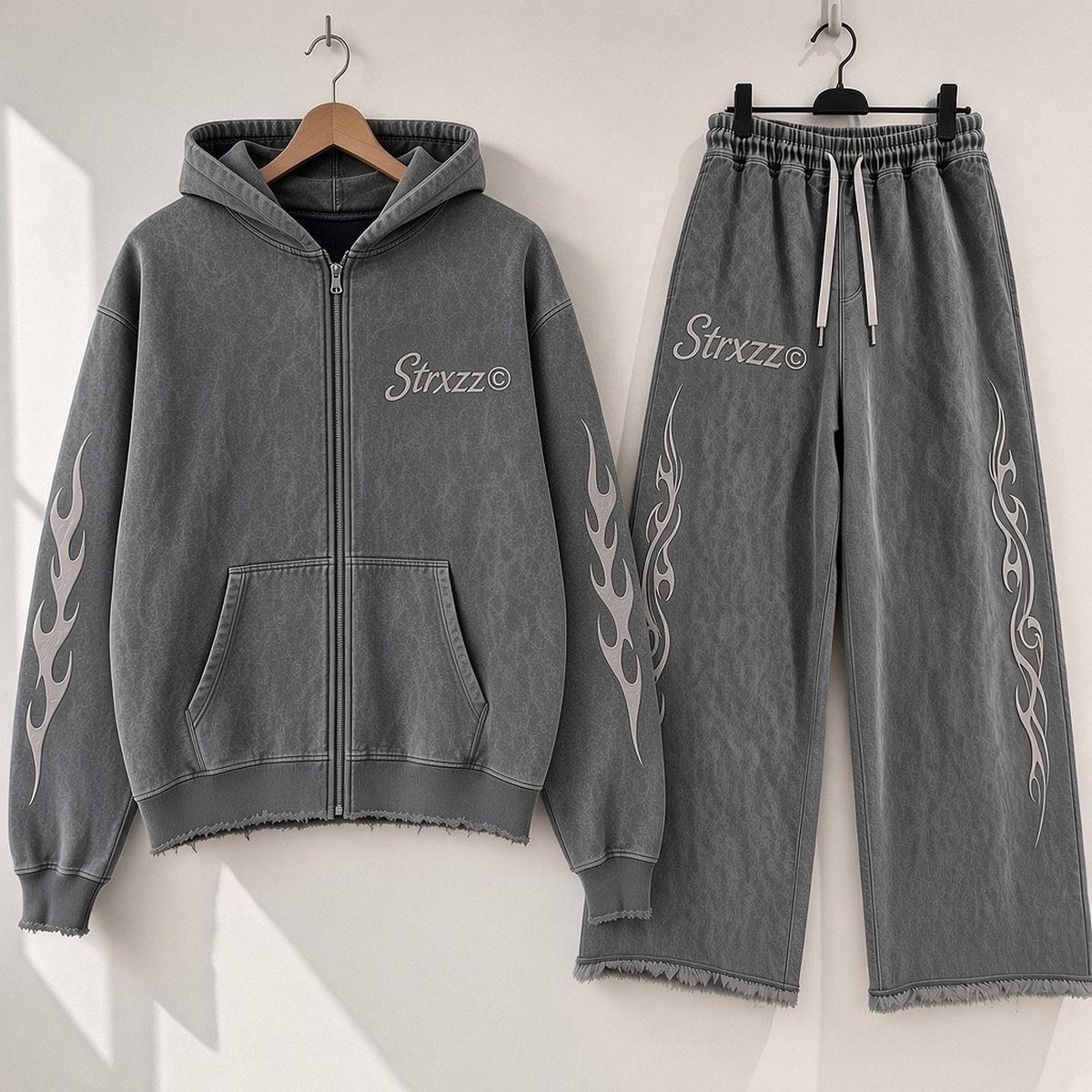 Strxzz Exclusive drop washed charcoal set, hoodie and joggers side by side on a white wall